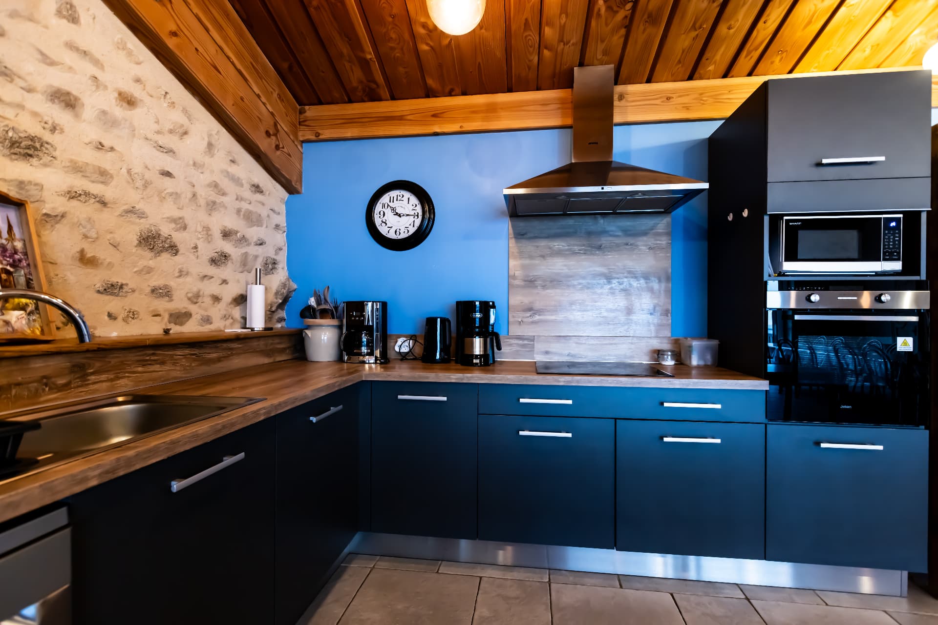 Cuisine équipée du Grand Planchat aux façades bleues et plan de travail en bois