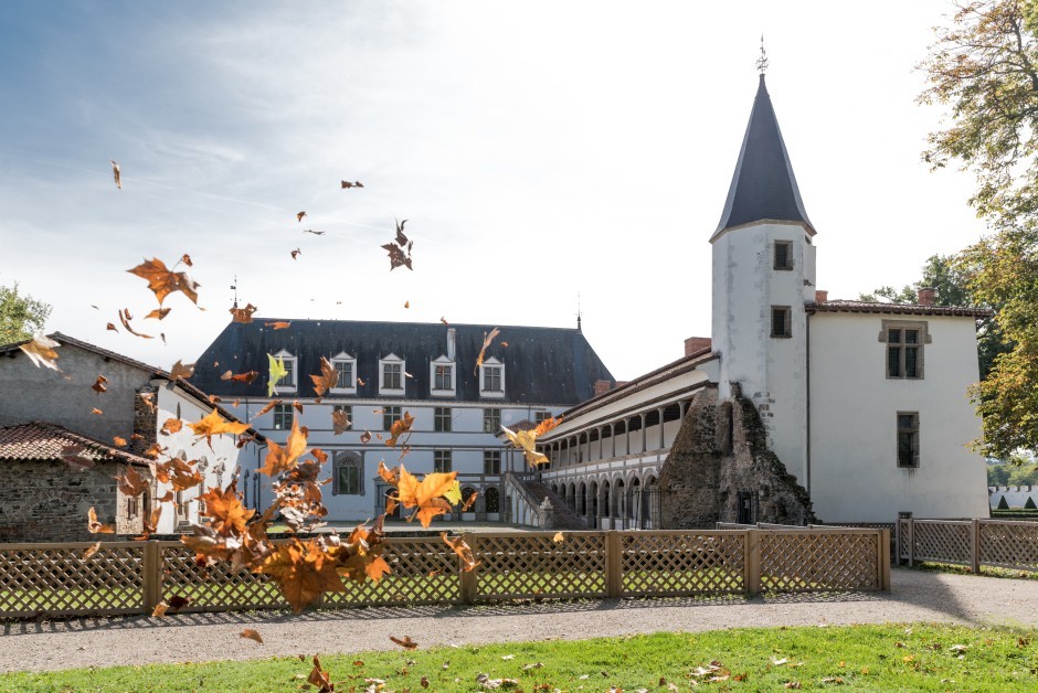 Château de la Bâtie d'Urfé en automne : tour à toit conique et galerie à arcades de la Renaissance, sous un ciel clair
