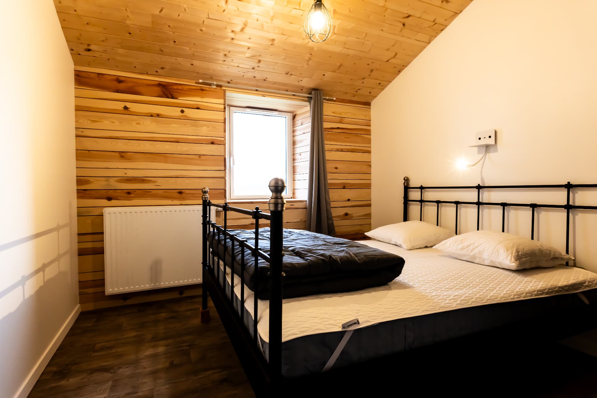 Chambre du Petit Planchat avec lit double et mur en bois