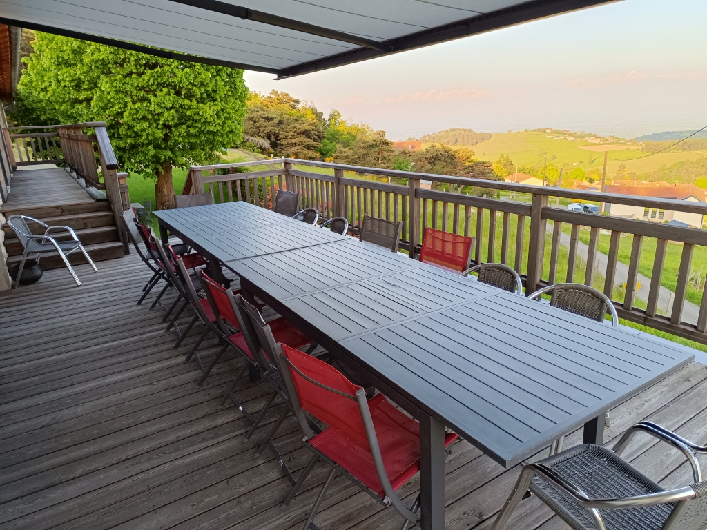 Grande table dressée sur la terrasse panoramique au coucher du soleil